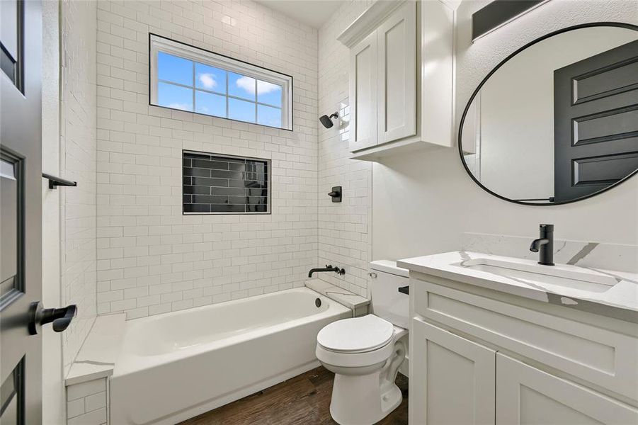 Full bath featuring vanity, shower / bathing tub combination, wood finished floors, and toilet