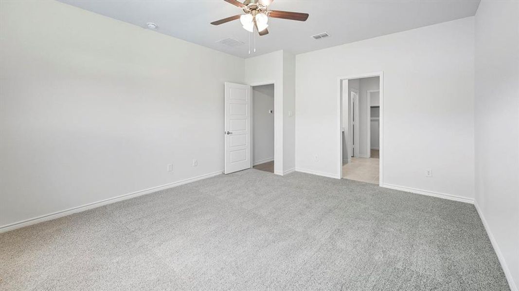 Unfurnished bedroom with light colored carpet and a ceiling fan