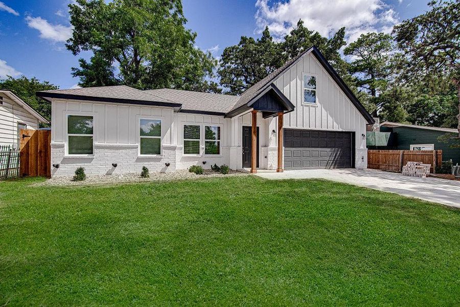 Modern farmhouse style home featuring a garage and a front yard