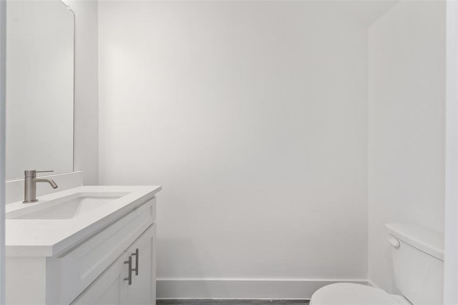 Half bathroom featuring vanity and toilet