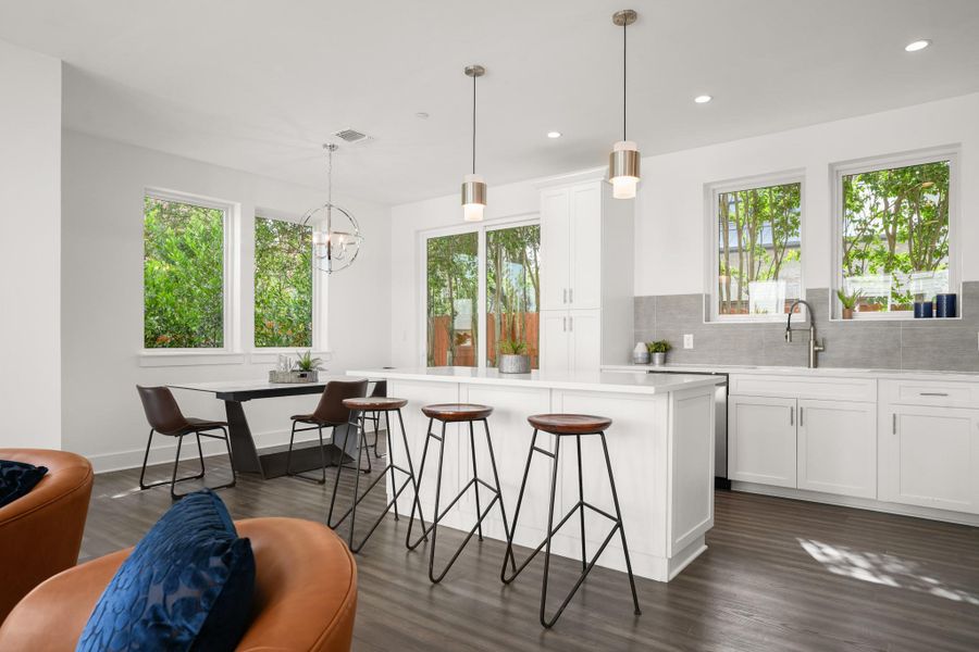 Bright, open-concept kitchen and dining area featuring clean lines and a lush outdoor connection. Bright, open-concept kitchen and dining area featuring clean lines and a lush outdoor connection.