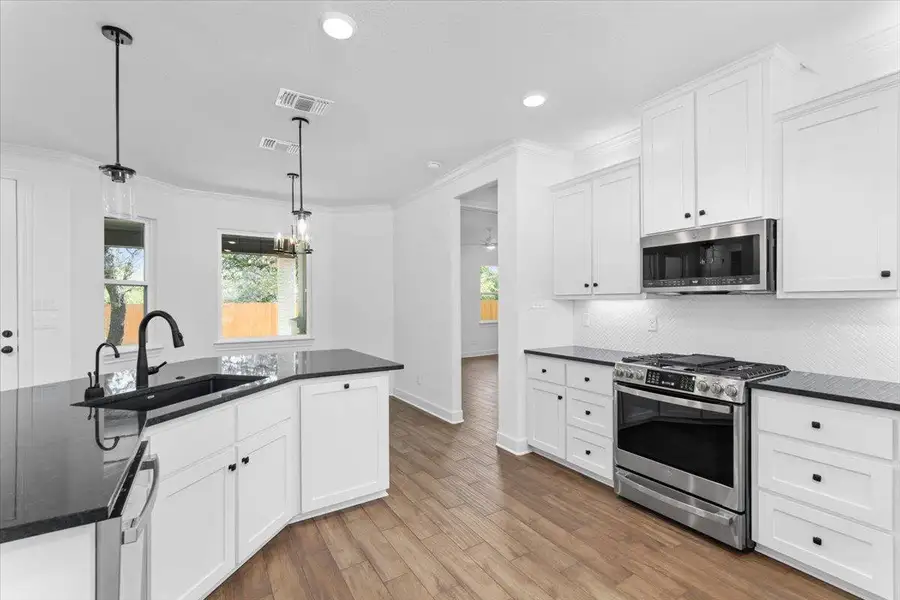 Kitchen featuring appliances with stainless steel finishes, a sink, white cabinets, decorative backsplash, and recessed lighting Kitchen featuring appliances with stainless steel finishes, a sink, white cabinets, decorative backsplash, and recessed lighting
