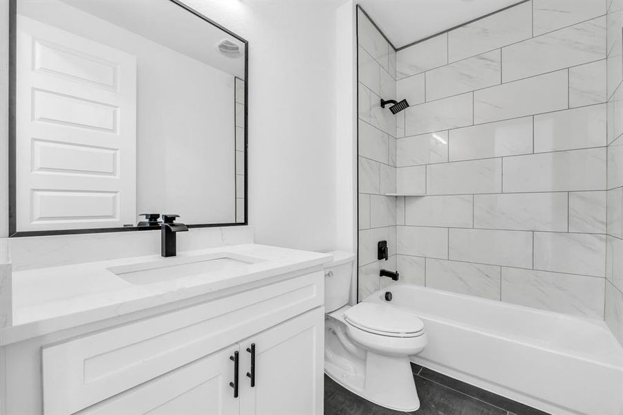 Full bathroom with vanity, toilet, and tiled shower / bath