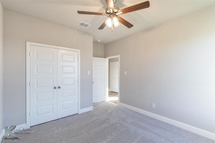 Unfurnished bedroom with carpet flooring, a ceiling fan, and a closet