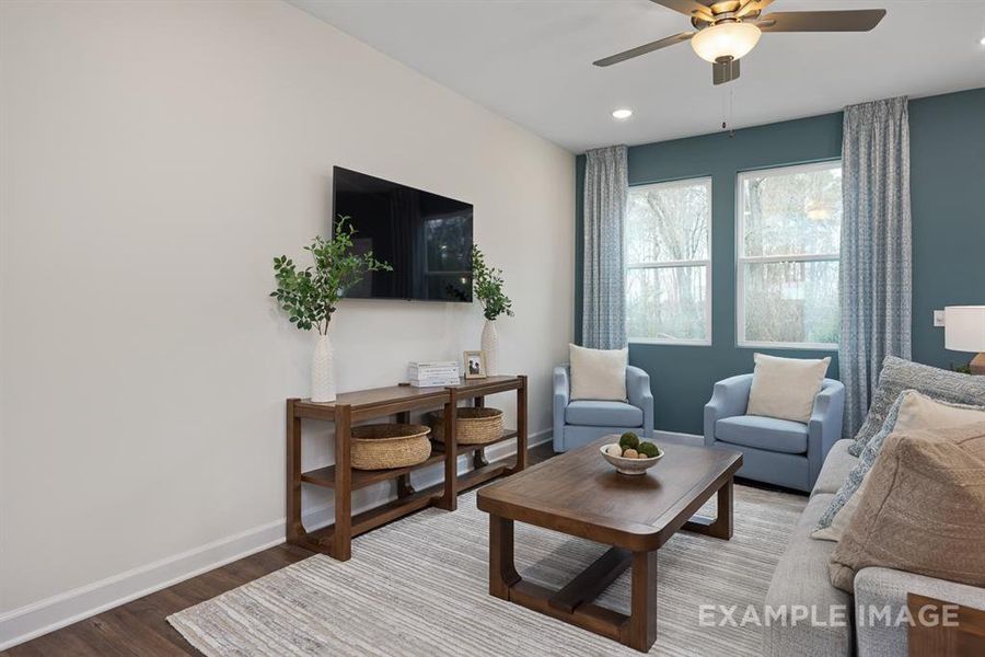 Living room with ceiling fan and hardwood / wood-style flooring