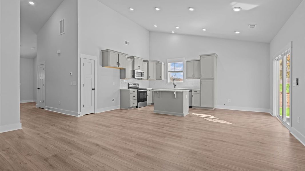 Tasteful family room with two-story volume, refined finishes, and exceptional natural light