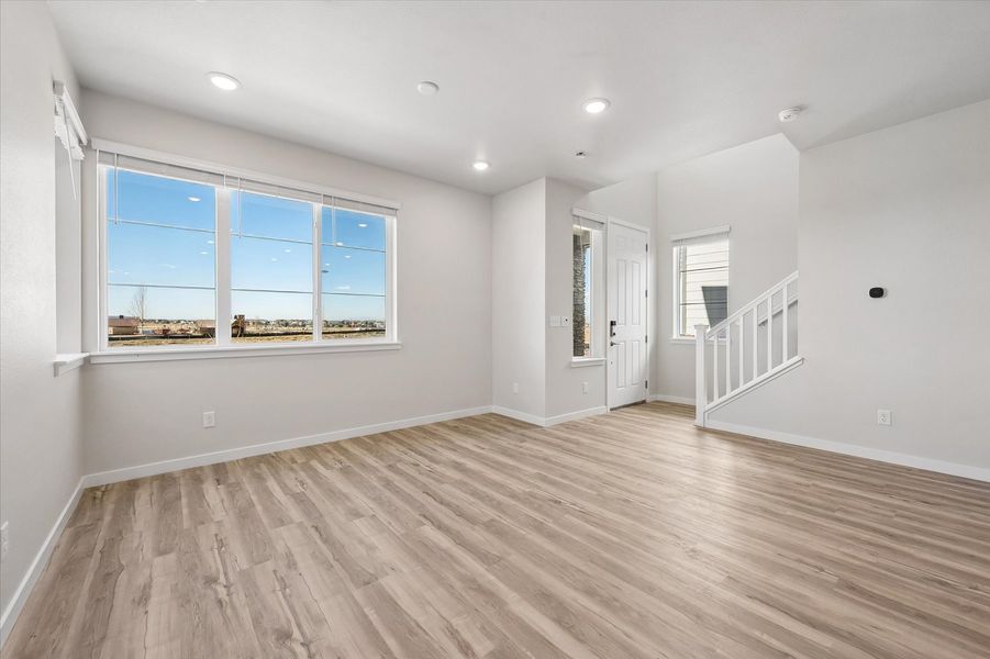 A room with a wood floor and a wood floor with a window.
