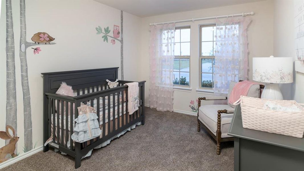 Carpeted bedroom with a crib and baseboards