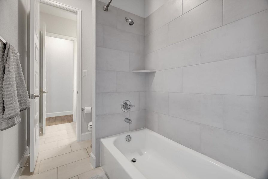 This shared Hollywood bath includes a well-designed shower-and-tub combo that provides direct access from both the second and third bedrooms, creating a functional and seamless layout.