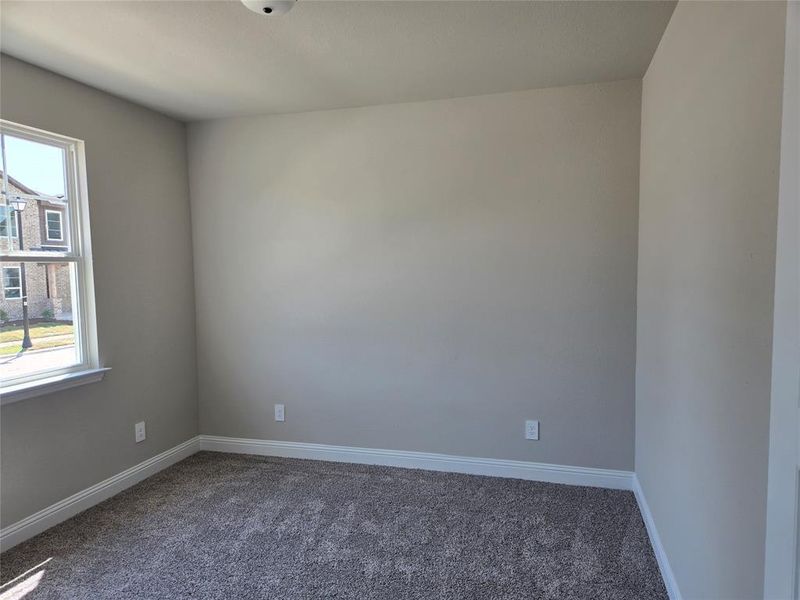 Carpeted empty room featuring baseboards