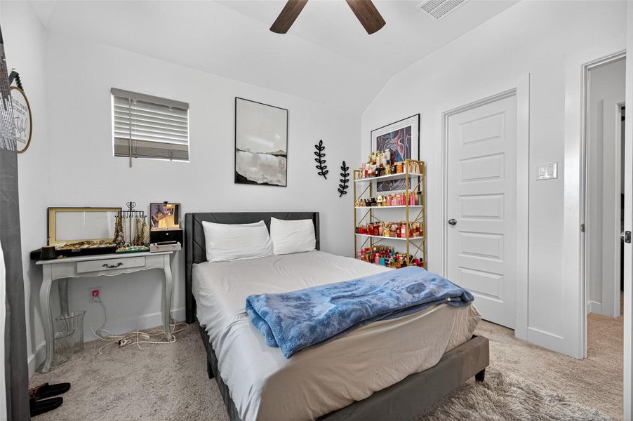 This cozy bedroom features neutral tones with a plush carpet and a ceiling fan. It includes a comfortable bed, a decorative side table, and a stylish shelving unit for storage. The room receives natural light through a small window, creating a bright and inviting space. This cozy bedroom features neutral tones with a plush carpet and a ceiling fan. It includes a comfortable bed, a decorative side table, and a stylish shelving unit for storage. The room receives natural light through a small window, creating a bright and inviting space.