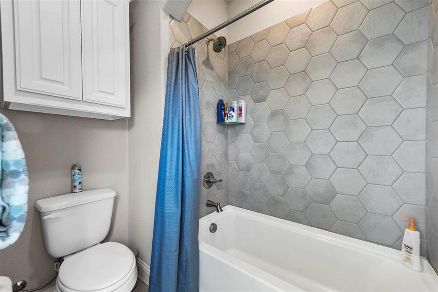 Bathroom featuring shower / bath combo with shower curtain and toilet