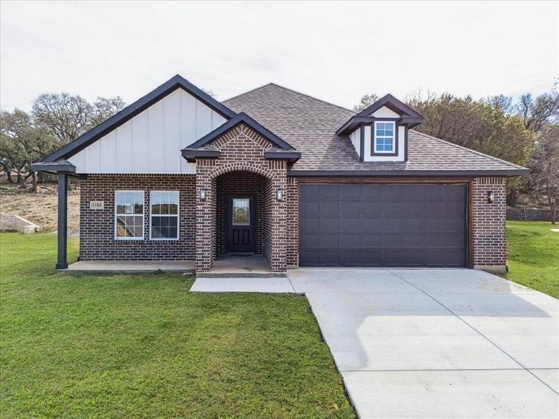 View of front of home with a front yard and a garage