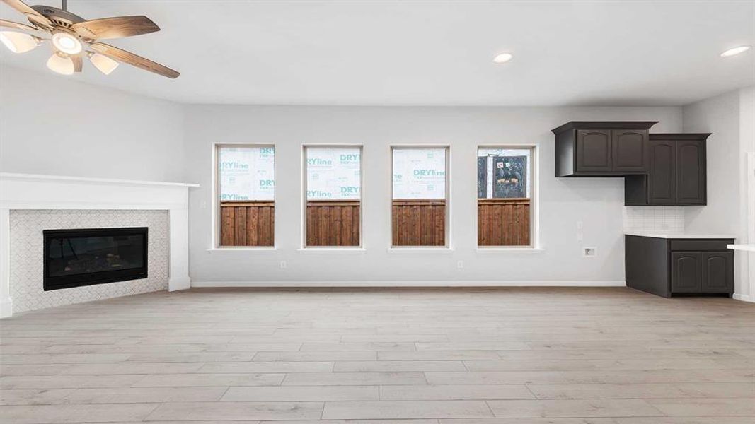 Unfurnished living room with ceiling fan and light hardwood / wood-style floors