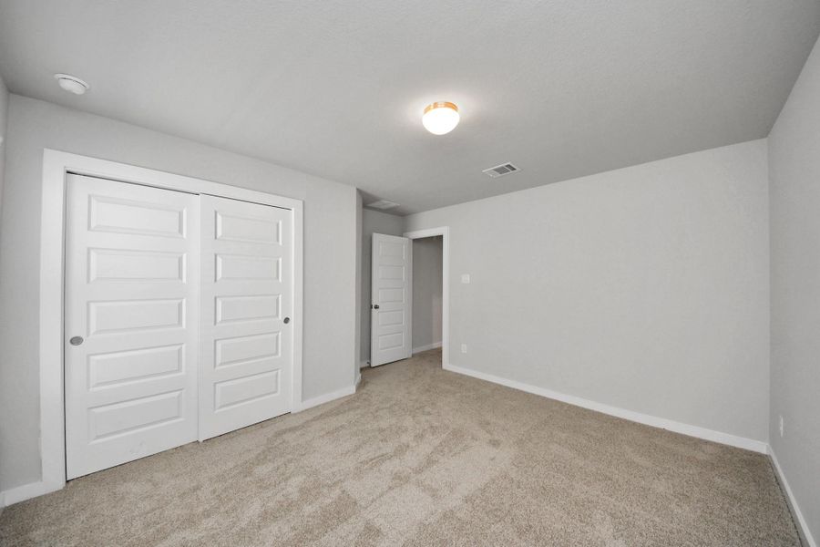 Generously sized secondary bedrooms featuring spacious closets, soft and inviting carpeting underfoot, large windows allowing plenty of natural light, and the added touch of privacy blinds for your personal retreat. Sample photo of completed home with similar floor plan. Actual colors and selections may vary.