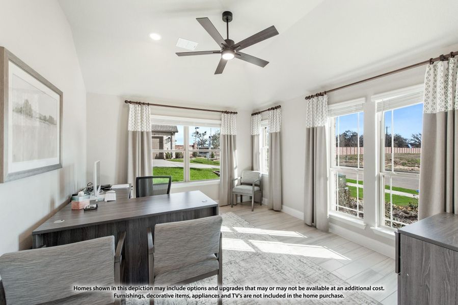 Home office with dark wood desk, ceiling fan, vaulted ceiling, and large windows with natural light