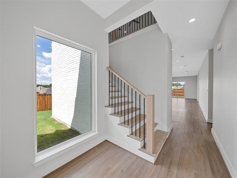 Staircase featuring a wealth of natural light and wood-type flooring