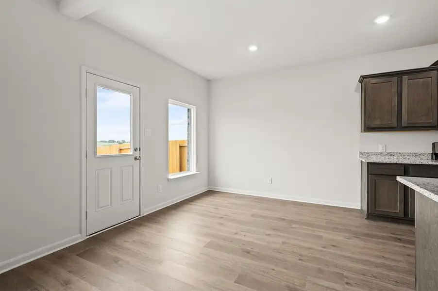 Unfurnished dining area featuring light wood-type flooring and baseboards