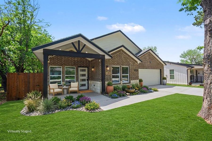 The property features an inviting front porch with seating, a well-maintained lawn, and mature landscaping