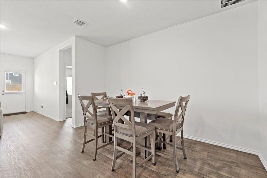 Dinner with a flow! Enjoy the seamless transition from the kitchen to the dining table, featuring bright recessed lighting and beautiful wood-style flooring that makes every meal feel like a special occasion.