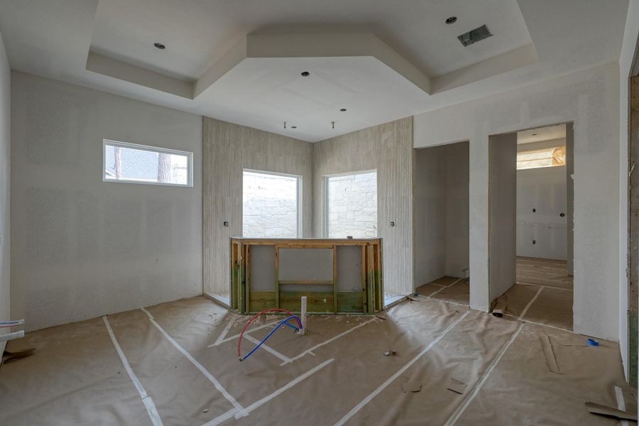 This spa-inspired bathroom blends indoor and outdoor living with a soaking tub, a double-entry rain shower, and a private garden backdrop that brings the feeling of nature and relaxation inside.