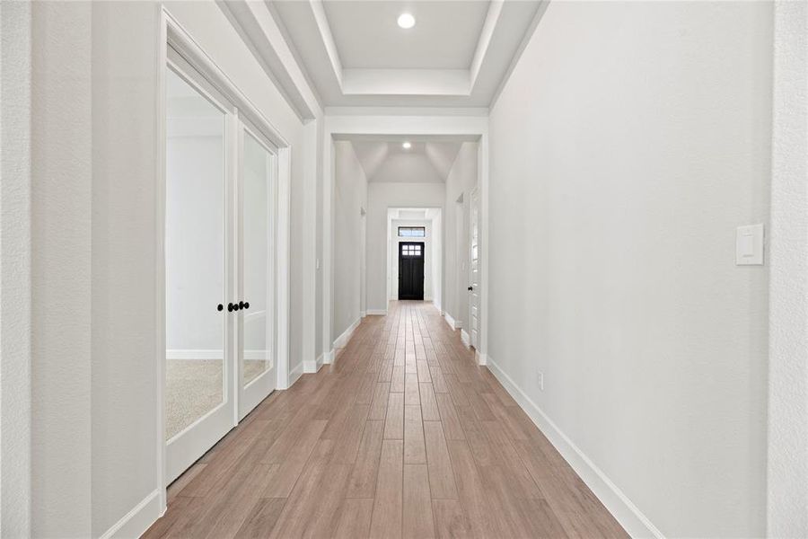 Beautiful entry boasts tray ceilings, wood-look tile flooring and neutral paint colors.