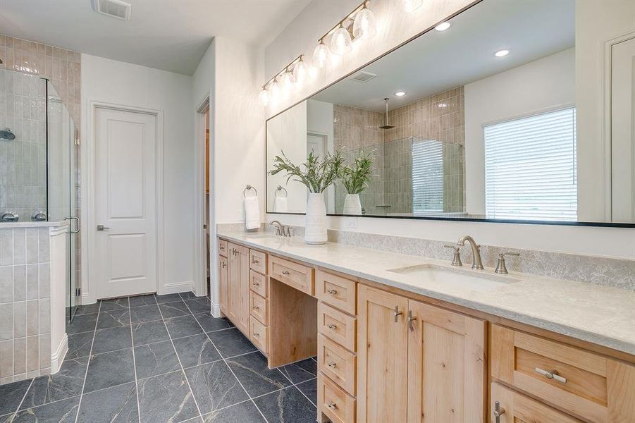 Primary bathroom with a separate shower, double vanity, level 4 Quartz countertops, huge framed mirror, and a garden tub.