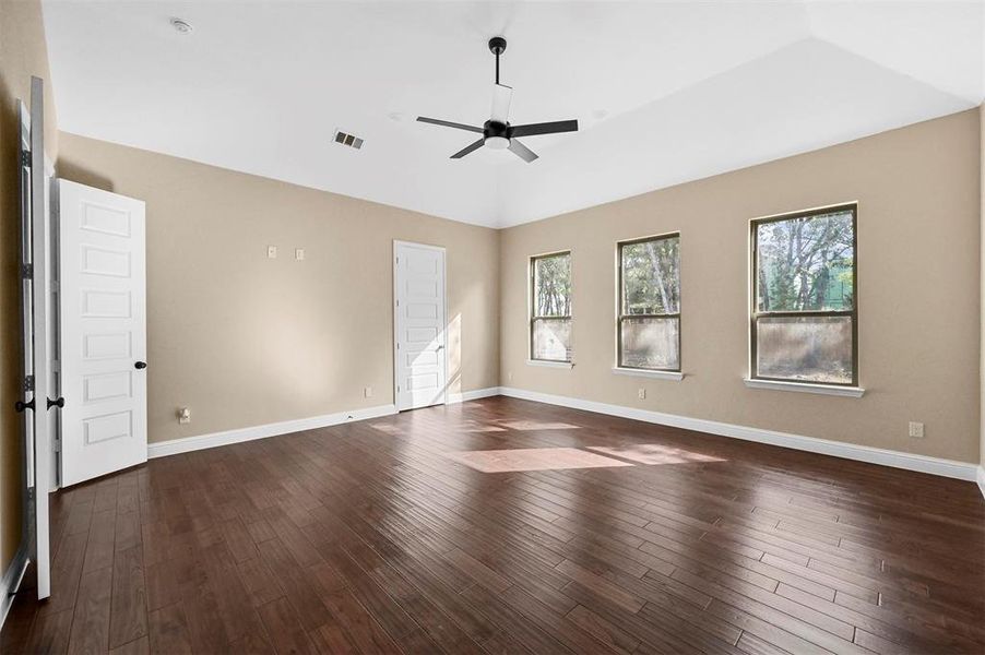 Unfurnished room with dark wood-type flooring and ceiling fan