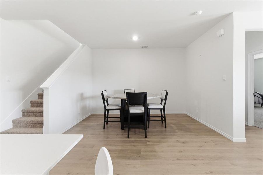 Dining area featuring light wood-style flooring and stairway Dining area featuring light wood-style flooring and stairway