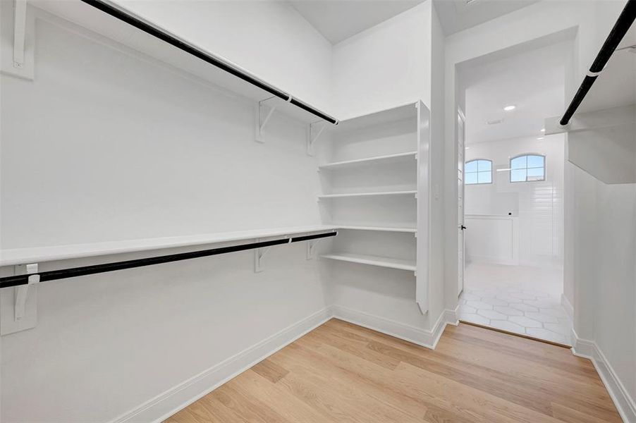Walk in closet featuring light wood-type flooring Walk in closet featuring light wood-type flooring