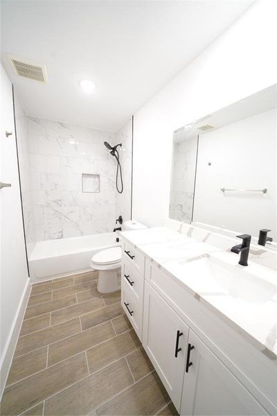 Full bathroom with vanity, a combined bath / shower with marble appearance, and wood finish floors