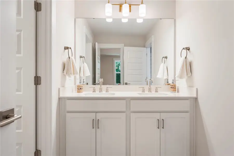 This modern bathroom features a double vanity with This modern bathroom features a double vanity with