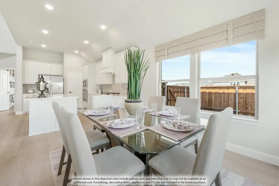 Open dining area with glass table and six chairs, adjacent to white kitchen with island and hardwood floors Open dining area with glass table and six chairs, adjacent to white kitchen with island and hardwood floors