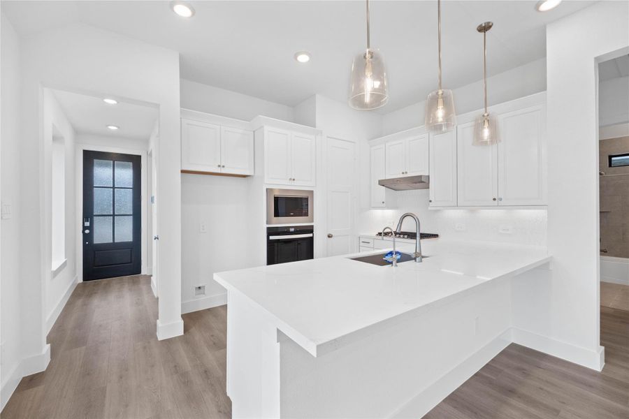 As you enter the home, you are greeted with natural light from the large window and recessed lighting. The laminate flooring ensuring a cohesive flow.