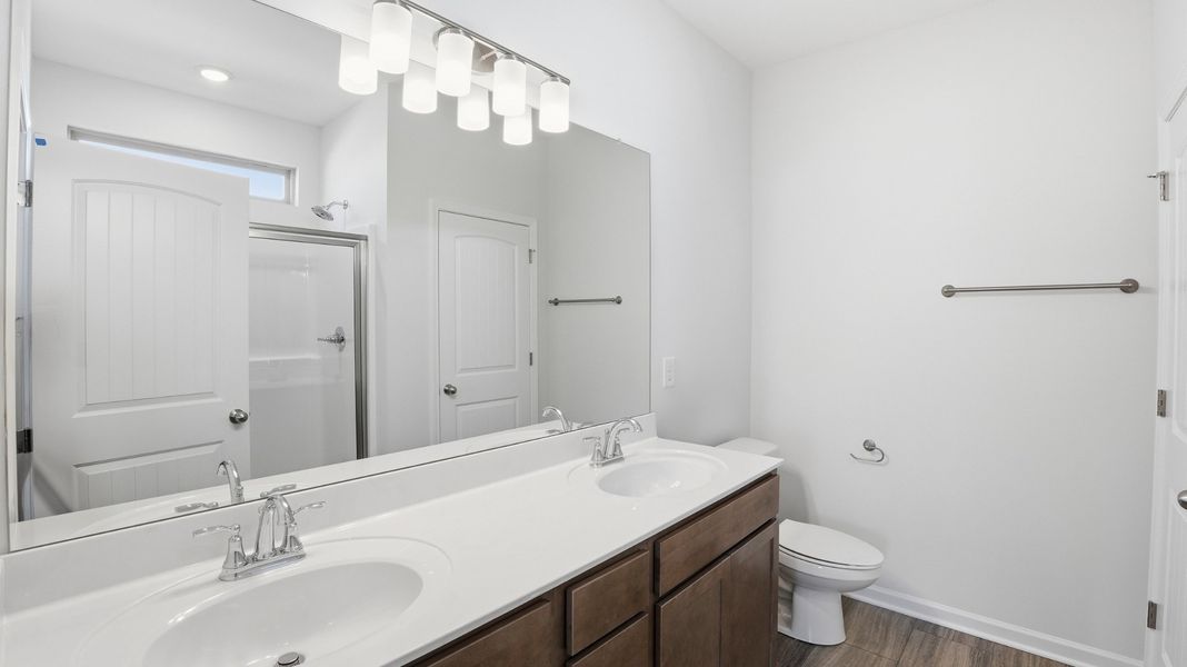primary bathroom with double sinks, linen closet, step in shower primary bathroom with double sinks, linen closet, step in shower