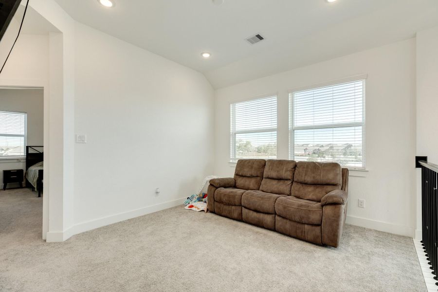 Alternate view of the spacious flex room, with views to the front door from the upper level. The entrance to the primary bedroom is located to the left.