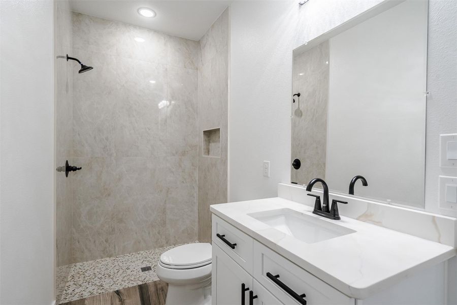 A well-appointed bathroom features a spacious shower and a modern vanity with a large mirror. A well-appointed bathroom features a spacious shower and a modern vanity with a large mirror.