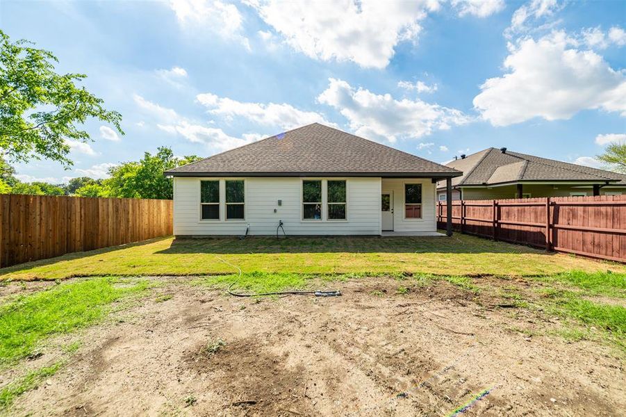 Rear view of property featuring a lawn