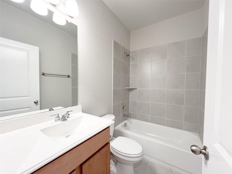 Full bathroom with vanity, shower / bathtub combination, a textured wall, and light tile patterned flooring