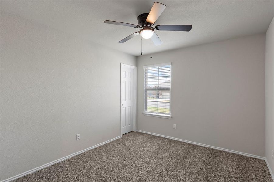 Carpeted spare room featuring baseboards and ceiling fan Carpeted spare room featuring baseboards and ceiling fan
