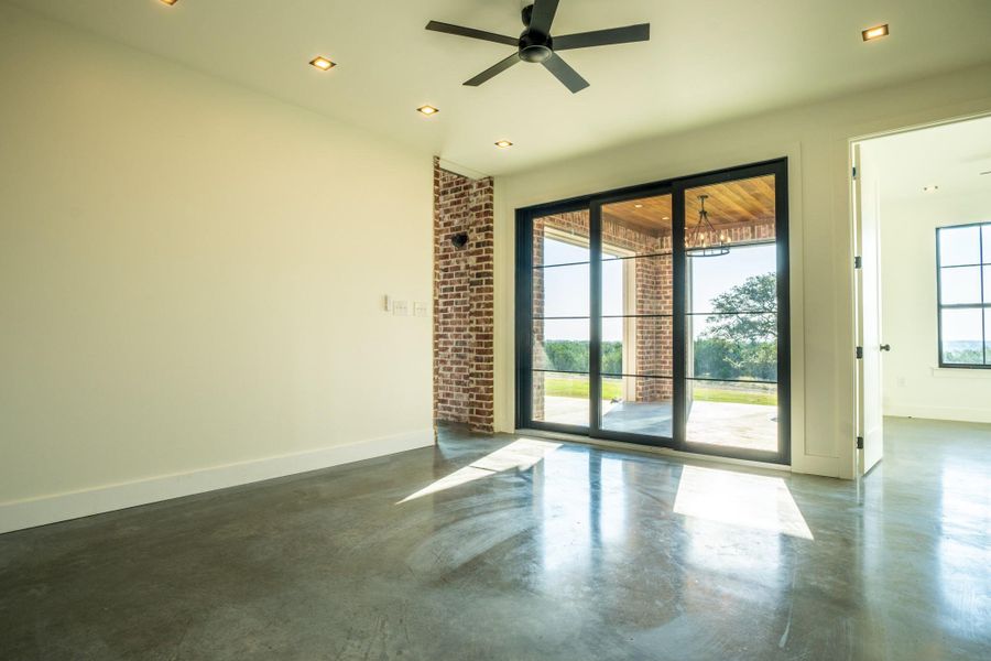 Empty room with finished concrete floors, healthy amount of natural light, ceiling fan, and recessed lighting