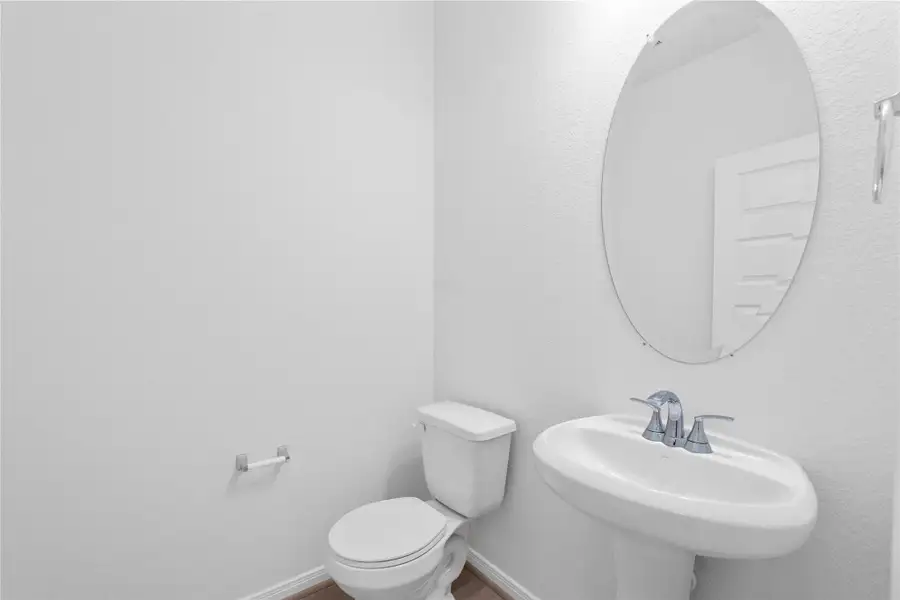 The powder room on the first floor includes a pedestal sink, mirror, and toilet to conveniently meet your needs. The powder room on the first floor includes a pedestal sink, mirror, and toilet to conveniently meet your needs.