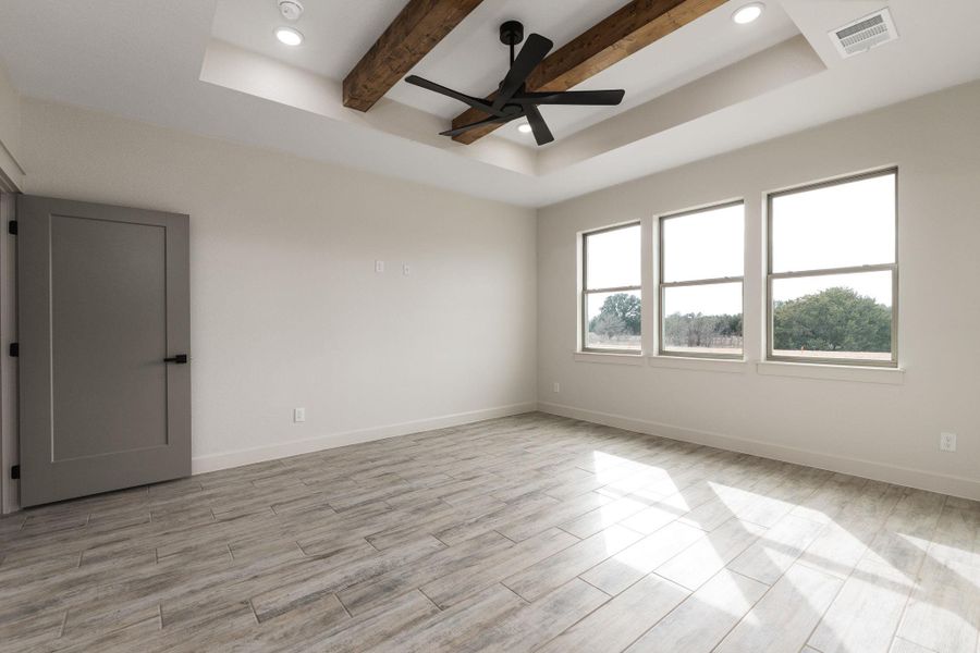 Unfurnished room featuring beamed ceiling, a tray ceiling, wood finish floors, recessed lighting, and ceiling fan