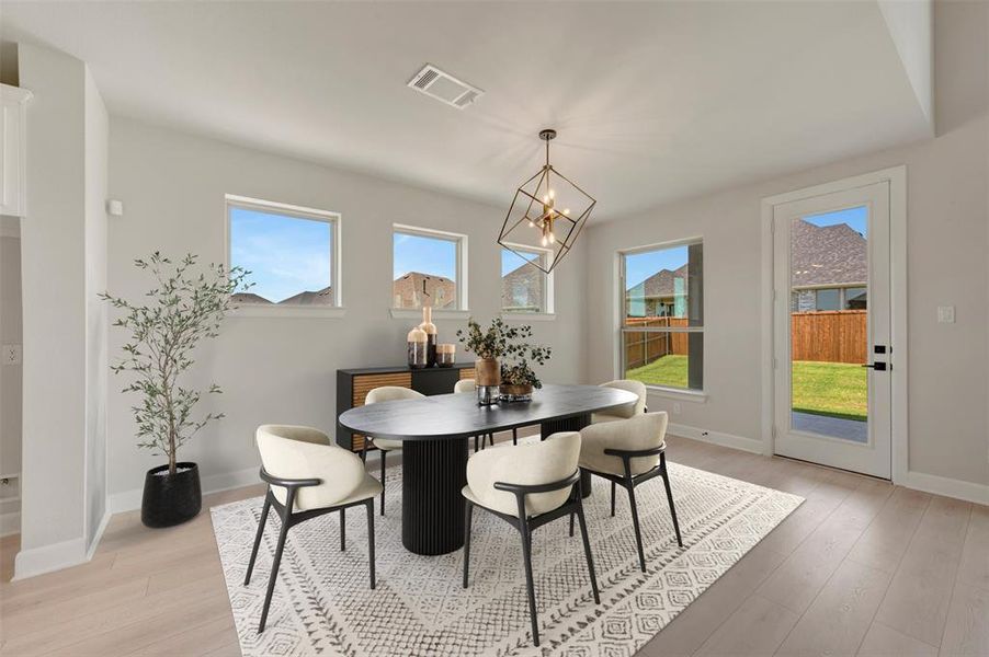 Dining area featuring light wood-finish flooring and a contemporary geometric chandelier
