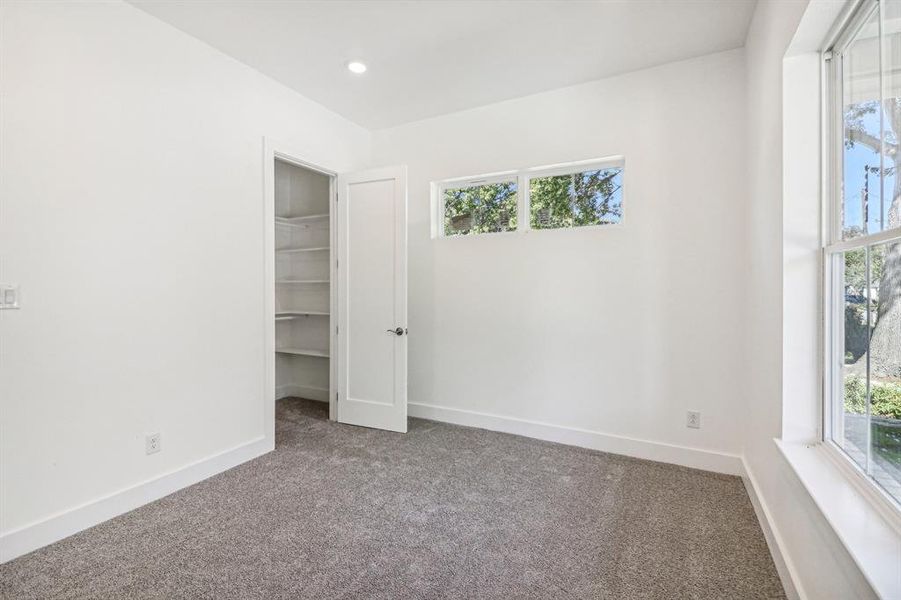 Unfurnished bedroom with carpet floors, a spacious closet, and recessed lighting Unfurnished bedroom with carpet floors, a spacious closet, and recessed lighting