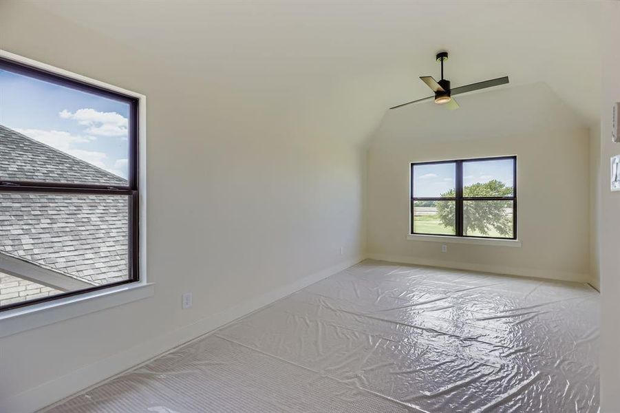 Bonus room with a ceiling fan and baseboards