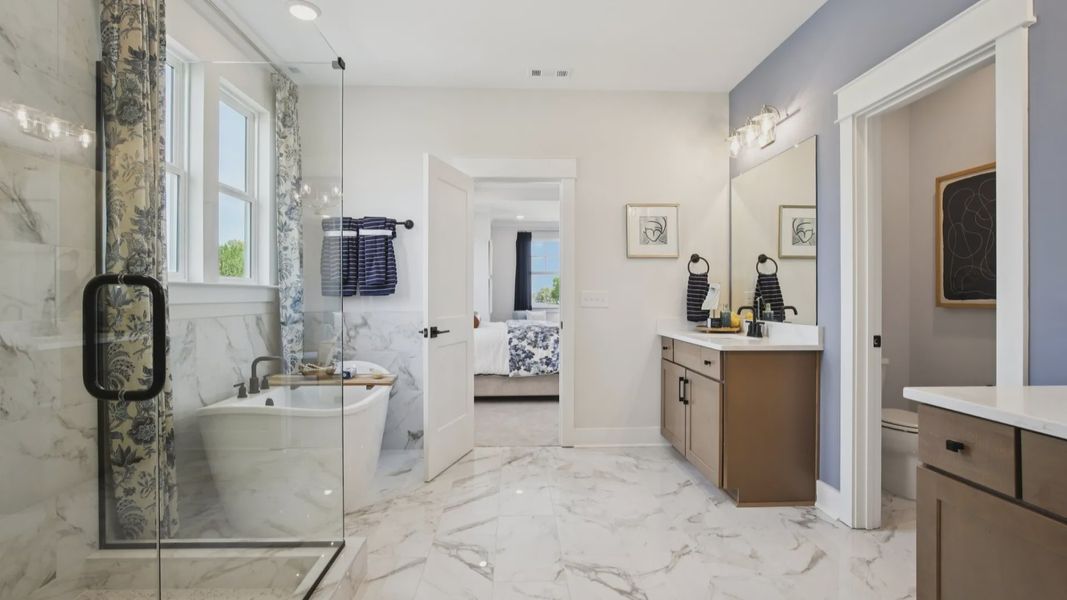 Tiled floor, free-standing tub surround, and shower with glass surround