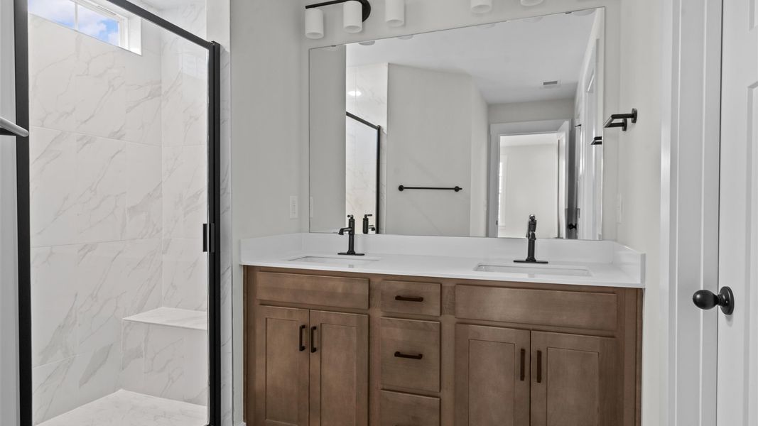 Superior en-suite primary bathroom with stylish dual vanity and tiled walk-in shower crafted with high standards in mind Superior en-suite primary bathroom with stylish dual vanity and tiled walk-in shower crafted with high standards in mind
