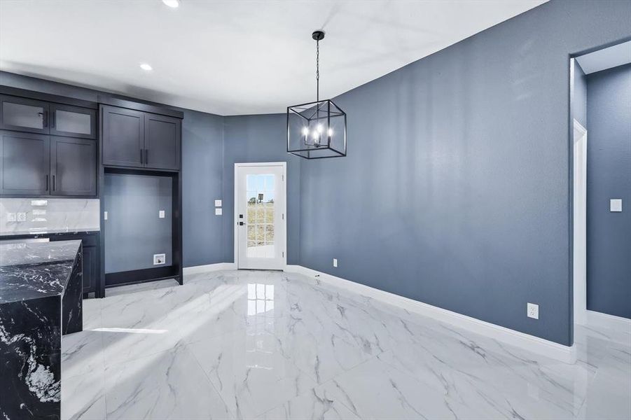 Unfurnished dining area featuring light marble finish flooring, a chandelier, and recessed lighting