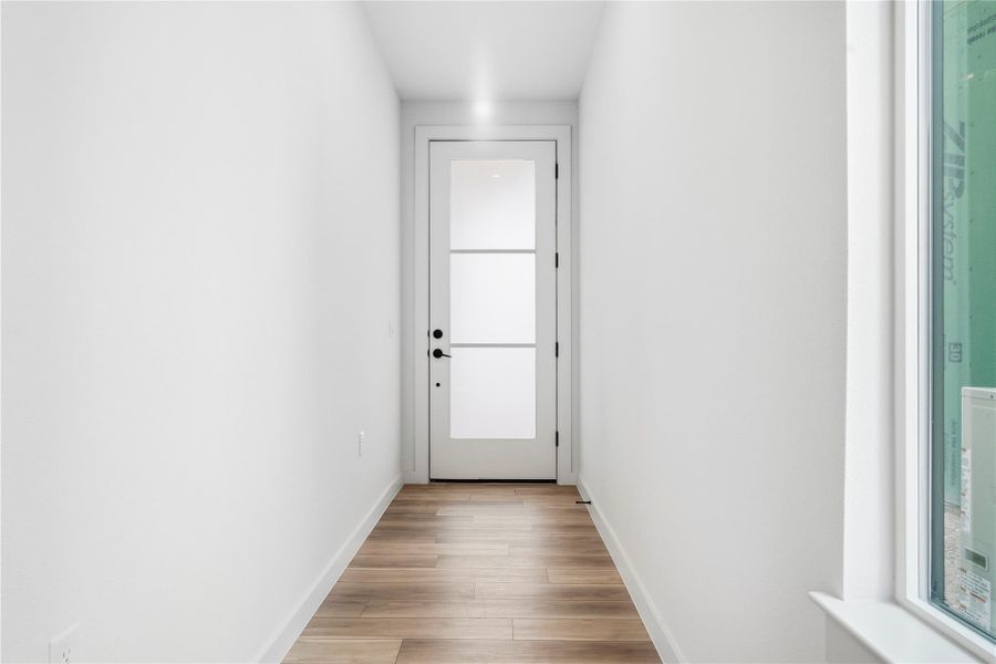 Doorway featuring baseboards and wood finished floors